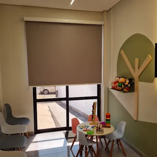 Ambiente interno da Clínica Policlin com cadeiras e espaço infantil